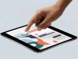 Close-up of a hand interacting with a tablet displaying a stylized online application for product compliance in India.