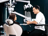 Dentist consulting with patient in a modern Aspen Dental office with digital dental equipment visible