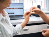 Patient consulting dentist about denture fitting while researching Rating for Aspen Dental for Denture Services and patient satisfaction