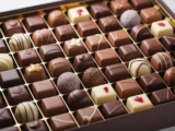 Luxurious gourmet chocolate gift box with assorted chocolates on a clean white background