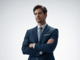Portrait of a confident business professional in a suit representing a securities fraud lawyer against a white background