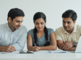 Indian family engaged in financial aid planning for college with documents and laptop on a clean white background