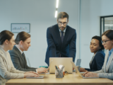Hero image of a modern small business workspace with professionals collaborating using technology on clean white background