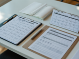 Close-up image of a college planning checklist alongside financial documents on a desk with bright natural lighting